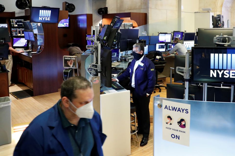 Traders with masks work on the first day of in-person trading since the closure during the outbreak of the coronavirus disease (COVID-19) on the floor at the New York Stock Exchange (NYSE) in New York, U.S., May 26, 2020. REUTERS/Brendan McDermid