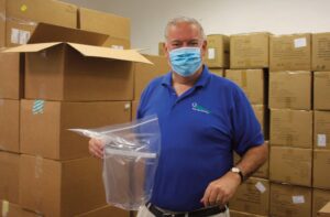 Thomas J. Grech, President and CEO of the Queens Chamber of Commerce stands amid boxes of face masks donated by the NYC Department of Small Business Services.